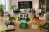 Lego-Figuren und -Bausteine kreisförmig um ein Projekt-Gebäude angeordnet, mit sechs beschrifteten Stationen: Verstehen, Strukturieren, Befähigen, Vertrauen, Begleiten und Feiern, im Hintergrund eine Tafel mit 'Mein Modell, wenn ein Projekt größer wird als ich'.
